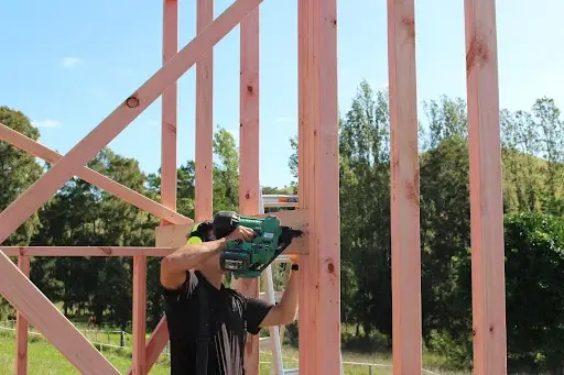 Builder fixing timber wall framing on site — MJones Building