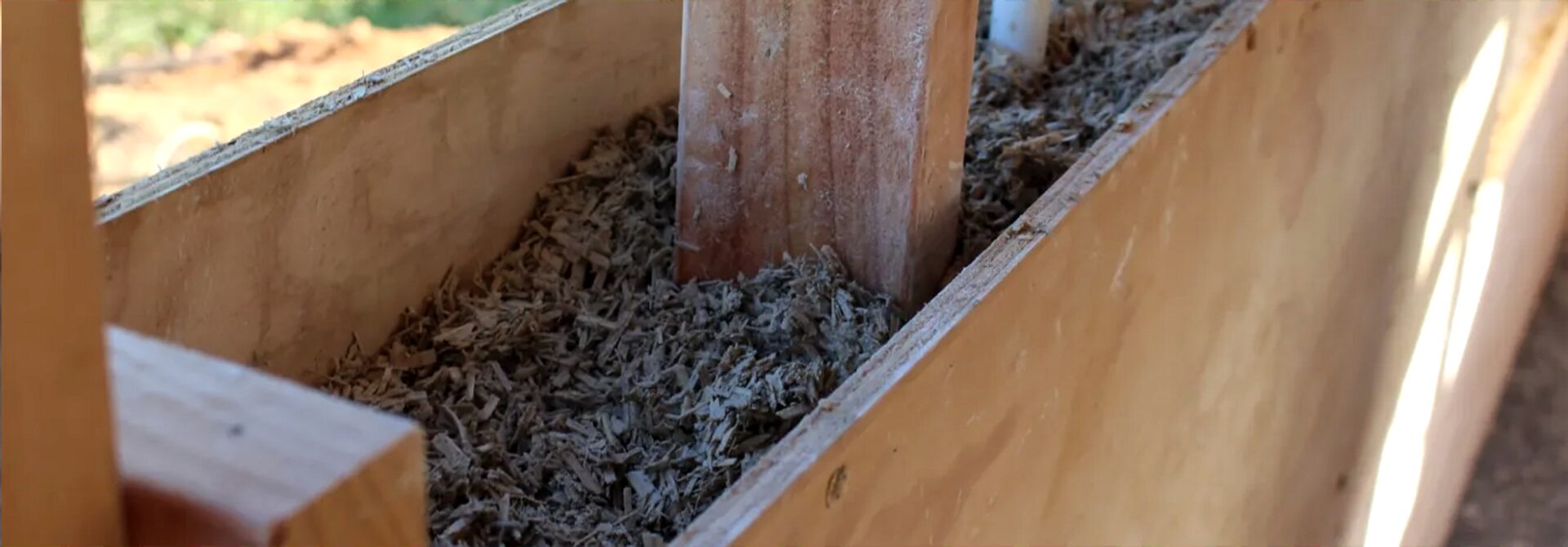 Hempcrete being tamped into timber formwork